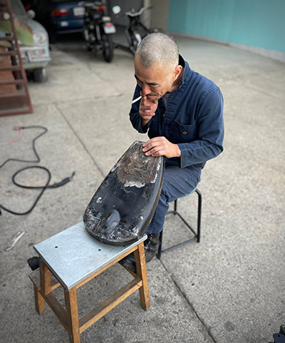 Man working to restore motorcycle parts
